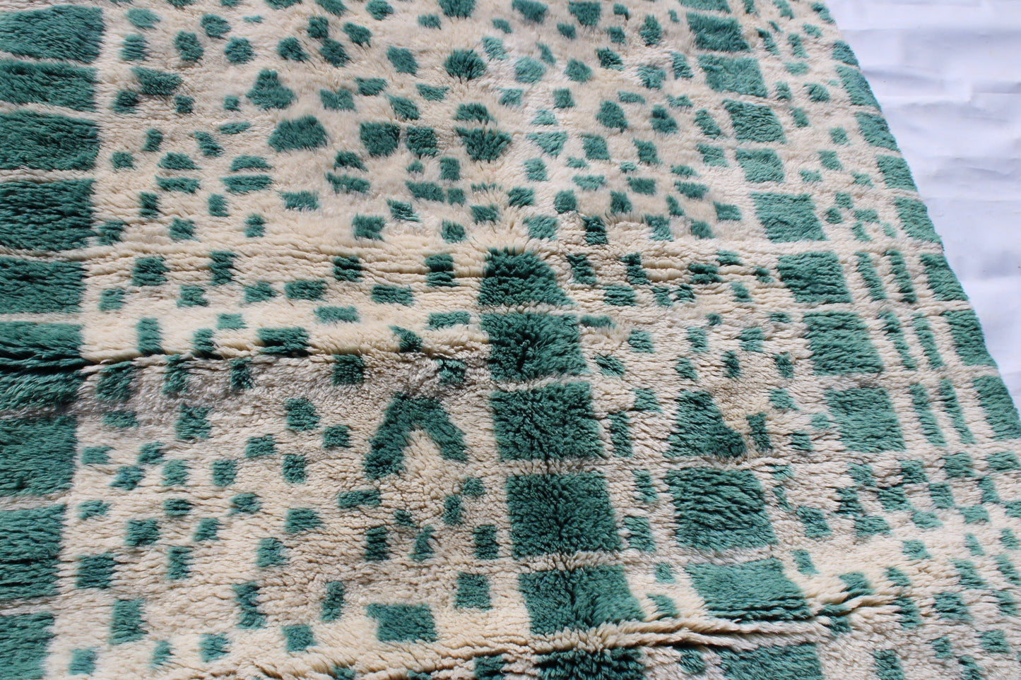Beni Ourain rugs originate from the Atlas Mountains of Morocco and are characterized by their distinctive, neutral-toned, and geometric designs. These handwoven rugs often feature a plush pile and are made by the Berber tribes, size is 215x160 cm