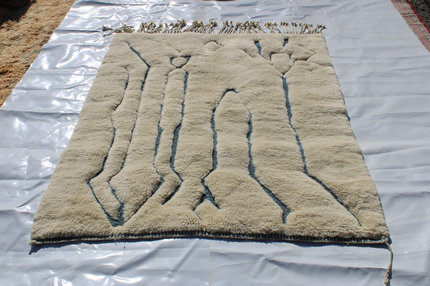 Beni Ourain rugs originate from the Atlas Mountains of Morocco and are characterized by their distinctive, neutral-toned, and geometric designs. These handwoven rugs often feature a plush pile and are made by the Berber tribes, size is 215x160 cm
