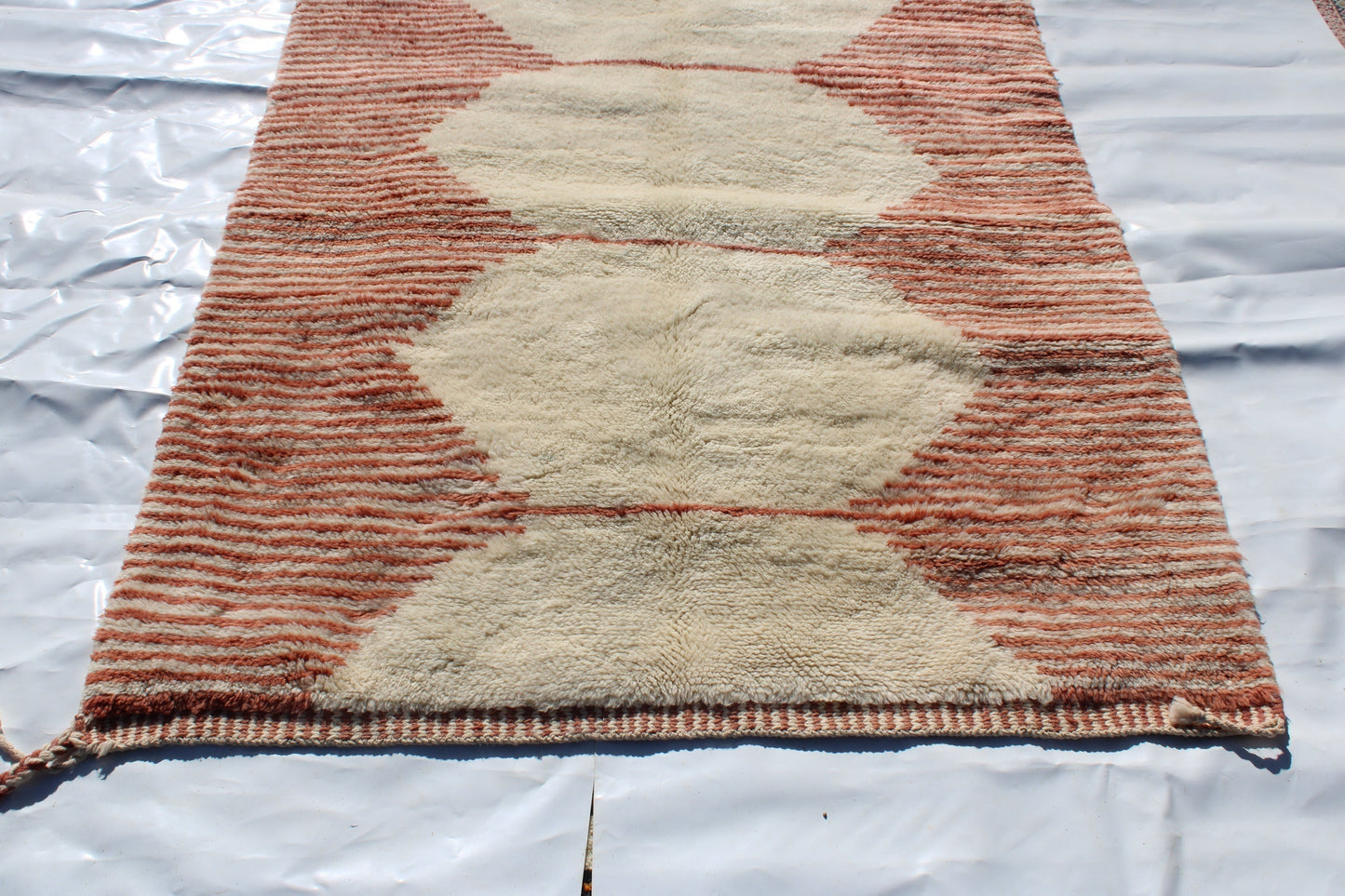 Beni Ourain rugs originate from the Atlas Mountains of Morocco and are characterized by their distinctive, neutral-toned, and geometric designs. These handwoven rugs often feature a plush pile and are made by the Berber tribes, size is 255x150 cm