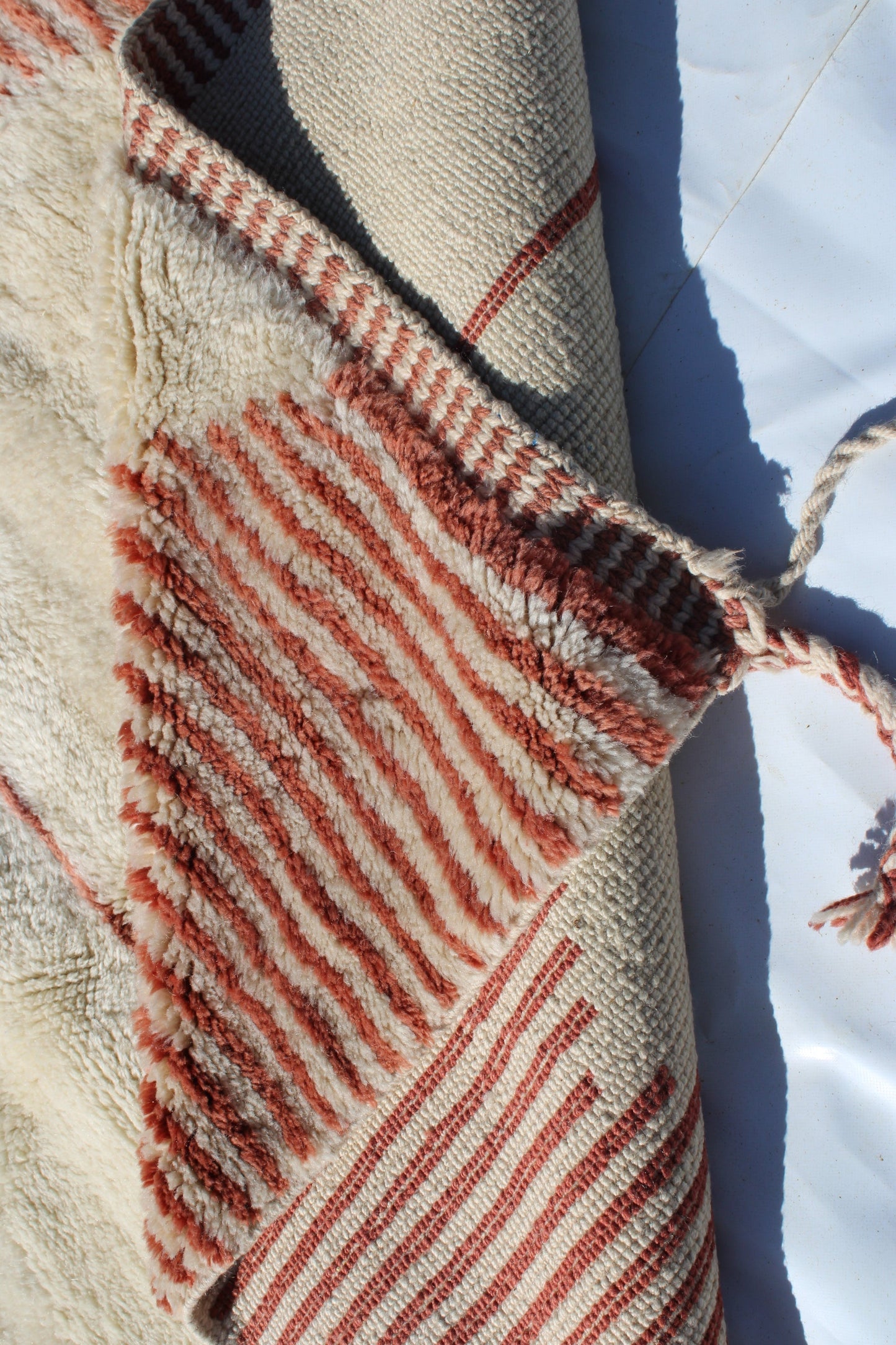 Beni Ourain rugs originate from the Atlas Mountains of Morocco and are characterized by their distinctive, neutral-toned, and geometric designs. These handwoven rugs often feature a plush pile and are made by the Berber tribes, size is 255x150 cm