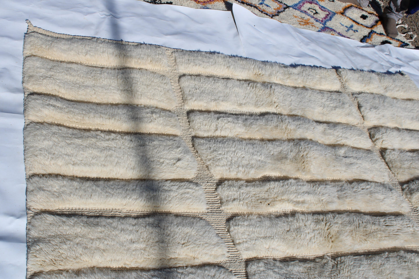 Beni Ourain rugs originate from the Atlas Mountains of Morocco and are characterized by their distinctive, neutral-toned, and geometric designs. These handwoven rugs often feature a plush pile and are made by the Berber tribes, size is 285x195 cm