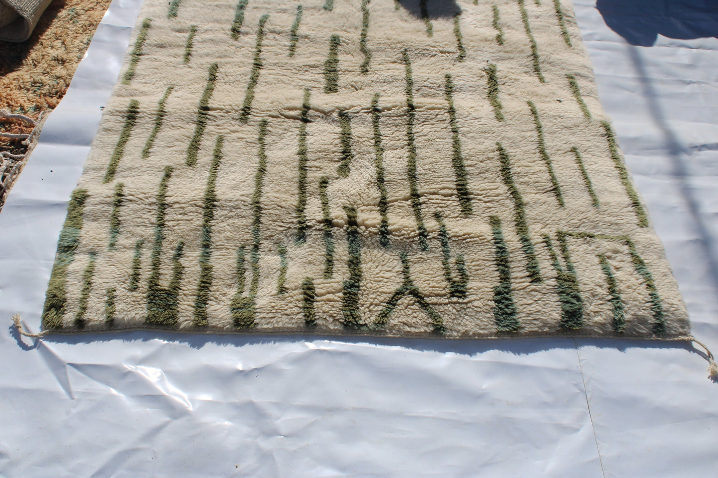 Beni Ourain rugs originate from the Atlas Mountains of Morocco and are characterized by their distinctive, neutral-toned, and geometric designs. These handwoven rugs often feature a plush pile and are made by the Berber tribes, size is 255x155 cm
