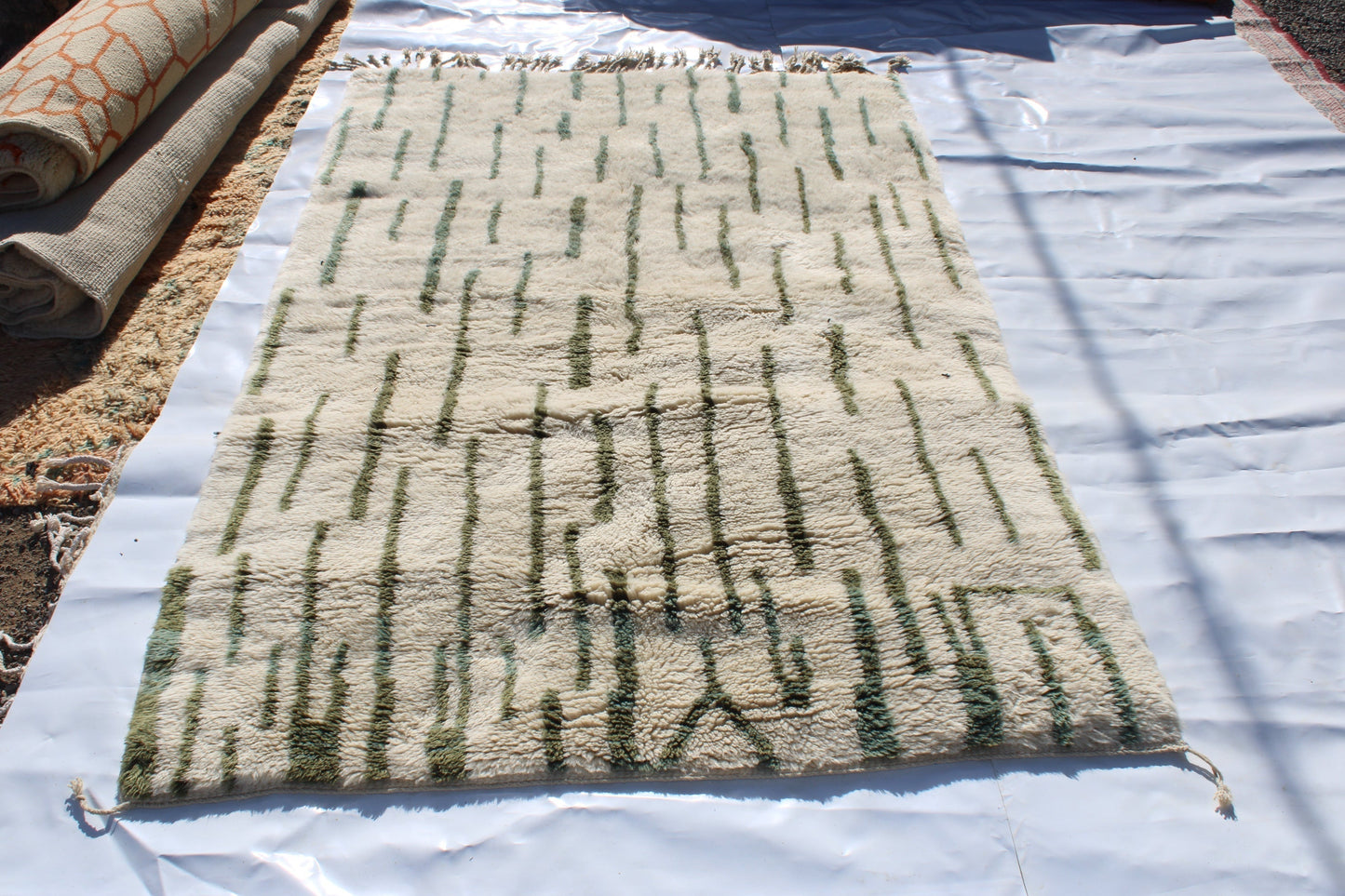 Beni Ourain rugs originate from the Atlas Mountains of Morocco and are characterized by their distinctive, neutral-toned, and geometric designs. These handwoven rugs often feature a plush pile and are made by the Berber tribes, size is 255x155 cm