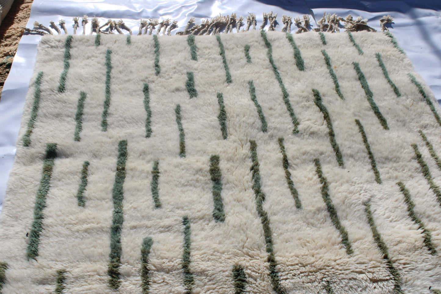 Beni Ourain rugs originate from the Atlas Mountains of Morocco and are characterized by their distinctive, neutral-toned, and geometric designs. These handwoven rugs often feature a plush pile and are made by the Berber tribes, size is 255x155 cm