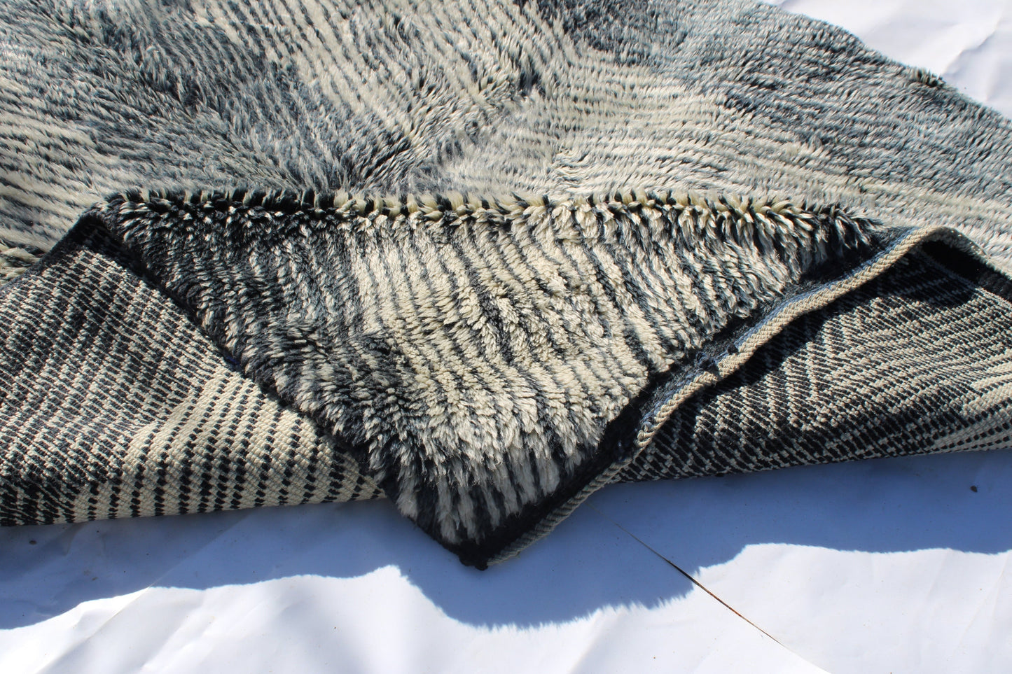 Beni Ourain rugs originate from the Atlas Mountains of Morocco and are characterized by their distinctive, neutral-toned, and geometric designs. These handwoven rugs often feature a plush pile and are made by the Berber tribes, size is 254x190 cm