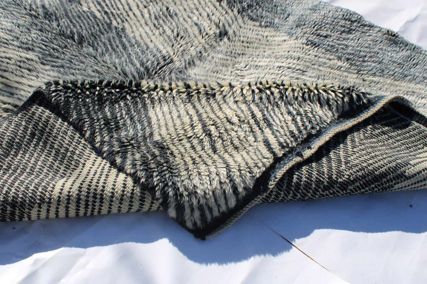 Beni Ourain rugs originate from the Atlas Mountains of Morocco and are characterized by their distinctive, neutral-toned, and geometric designs. These handwoven rugs often feature a plush pile and are made by the Berber tribes, size is 254x190 cm