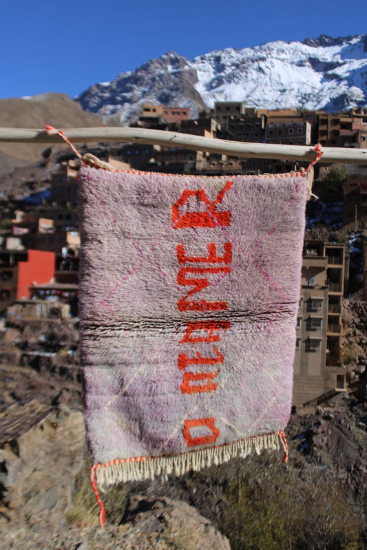 dreamer rug, word art rug, inspirational rug, moroccan wool rug, beni ourain style, berber handmade, cooperative adrar, atlas mountains craft, pink wool rug, orange lettering rug, small accent rug, wall hanging rug, boho home decor, creative decor, artisan rug, handmade moroccan carpet, tribal textile, cozy wool decor, unique handmade rug, studio decor